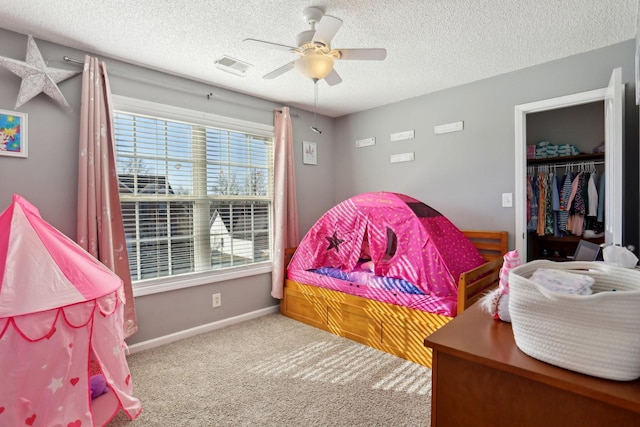 bedroom featuring ceiling fan, a closet, a textured ceiling, and carpet flooring