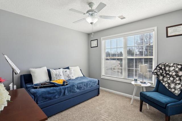 carpeted bedroom featuring ceiling fan and a textured ceiling