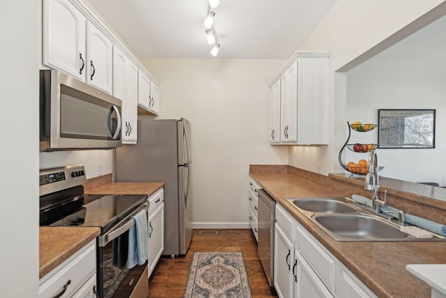 kitchen with stainless steel appliances, sink, white cabinets, and dark hardwood / wood-style flooring