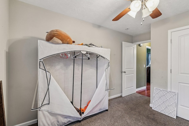 bedroom with ceiling fan, a textured ceiling, and dark carpet