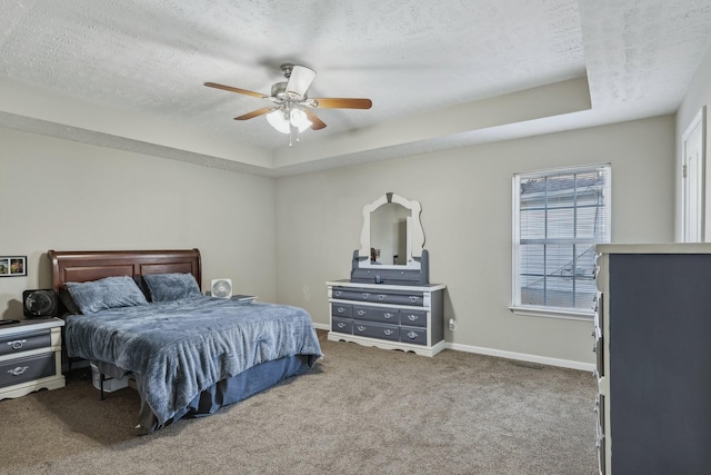 bedroom featuring a tray ceiling, carpet, and a textured ceiling