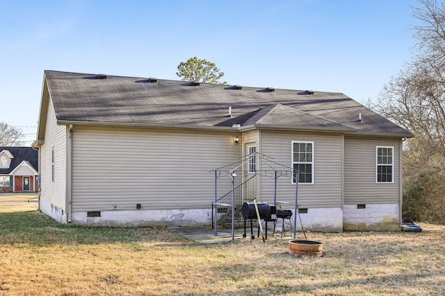 rear view of property featuring a lawn