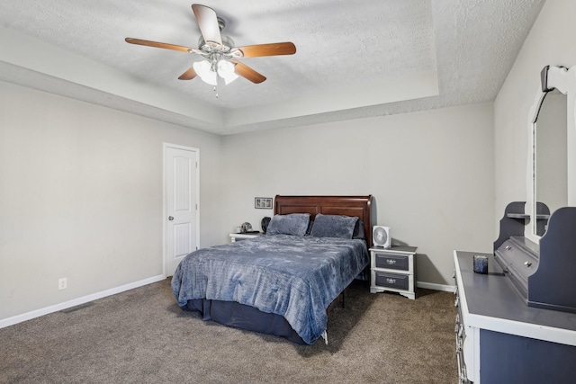 carpeted bedroom with a raised ceiling, ceiling fan, and a textured ceiling