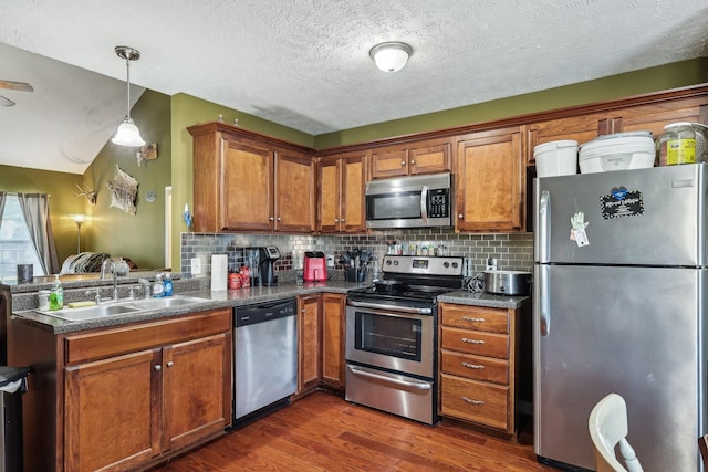 kitchen with sink, appliances with stainless steel finishes, dark hardwood / wood-style floors, decorative backsplash, and decorative light fixtures