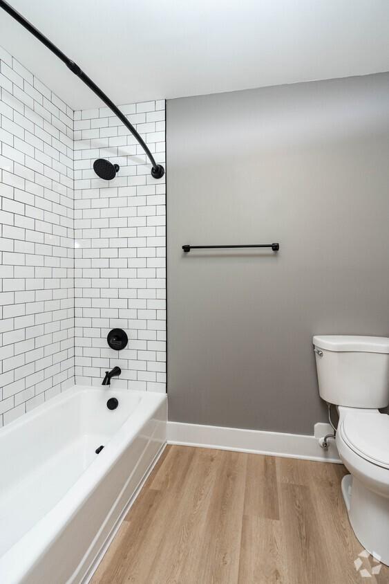 bathroom featuring tiled shower / bath combo, wood-type flooring, and toilet