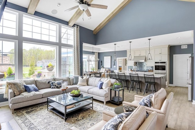 living room with beamed ceiling, ceiling fan, high vaulted ceiling, and light hardwood / wood-style floors