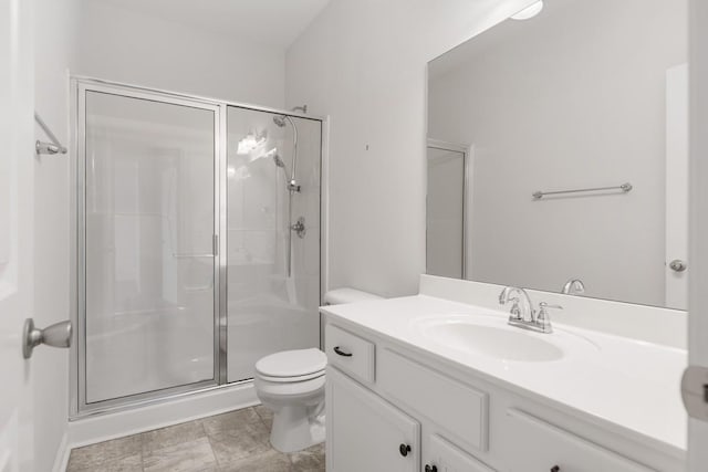 bathroom with vanity, a shower with door, and toilet