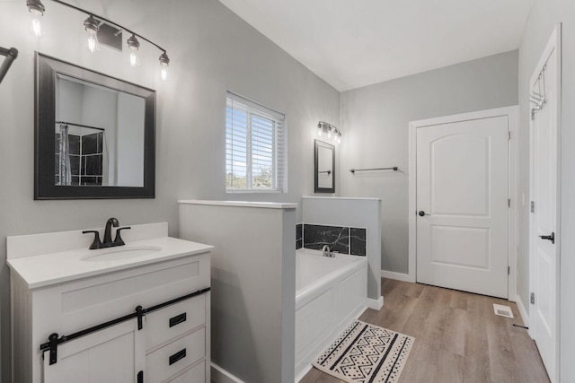 bathroom featuring vanity, a bathtub, and hardwood / wood-style floors