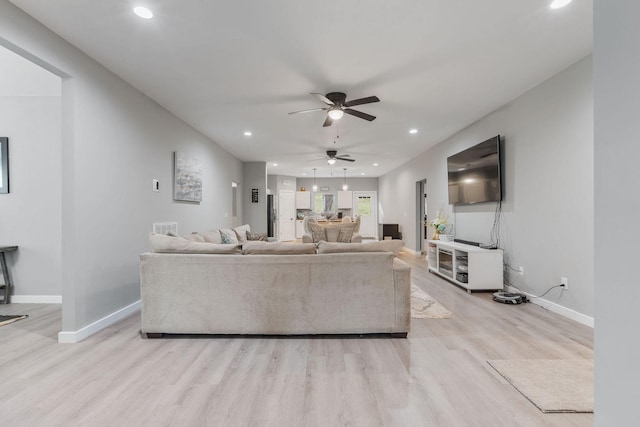 living room with ceiling fan and light hardwood / wood-style floors