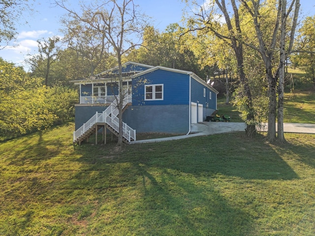 view of front of house with a garage, covered porch, and a front lawn