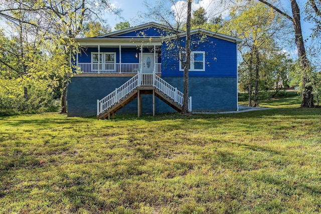 rear view of property featuring a lawn