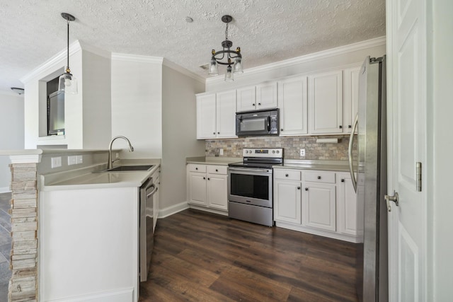 kitchen featuring appliances with stainless steel finishes, white cabinetry, sink, dark hardwood / wood-style flooring, and hanging light fixtures