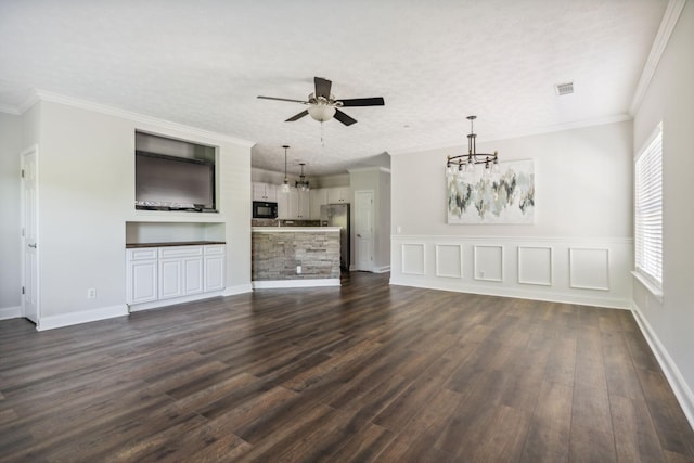 unfurnished living room featuring ornamental molding, dark hardwood / wood-style flooring, ceiling fan with notable chandelier, and a textured ceiling