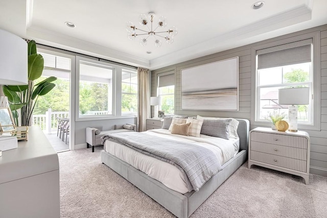 carpeted bedroom featuring ornamental molding, access to outside, and an inviting chandelier