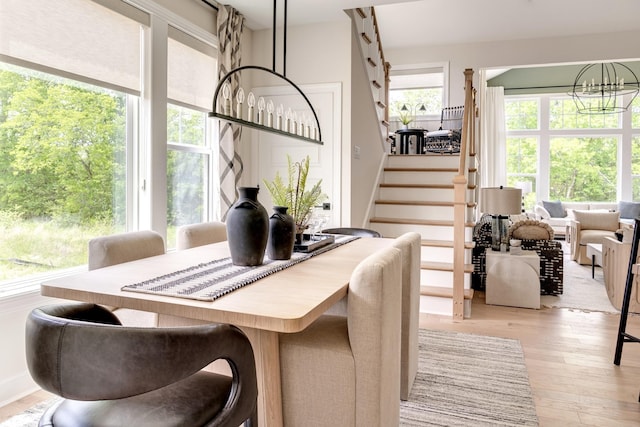 dining space with an inviting chandelier and light hardwood / wood-style flooring