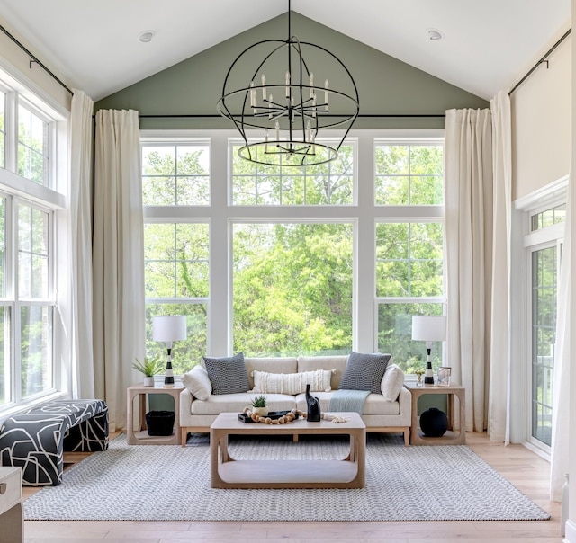 sunroom / solarium featuring lofted ceiling and a notable chandelier