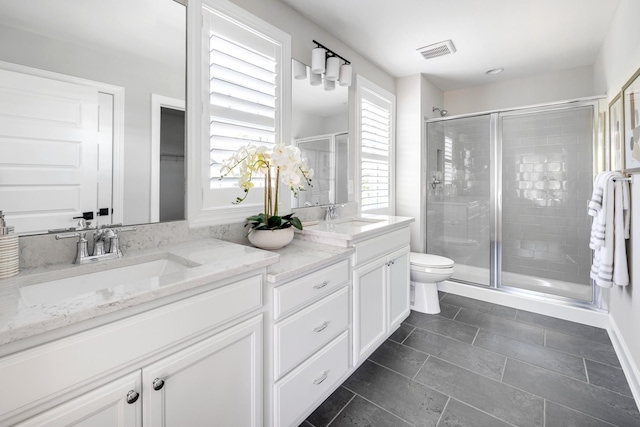 bathroom with vanity, toilet, and a shower with shower door