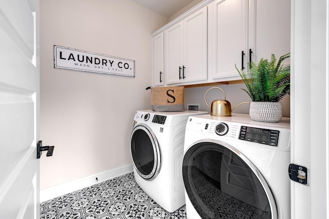 clothes washing area featuring cabinets, light tile patterned floors, and washing machine and clothes dryer