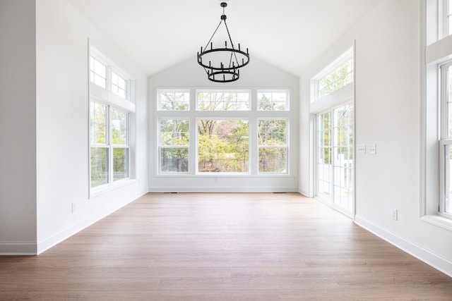 unfurnished sunroom featuring vaulted ceiling, a wealth of natural light, and an inviting chandelier