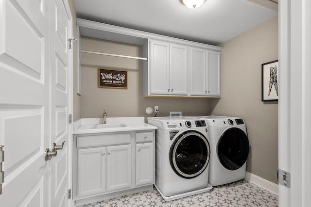 laundry room with cabinets, separate washer and dryer, and sink