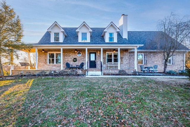 new england style home with a porch and a front yard