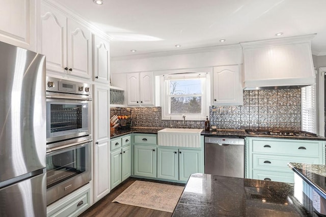 kitchen with premium range hood, sink, tasteful backsplash, stainless steel appliances, and white cabinets