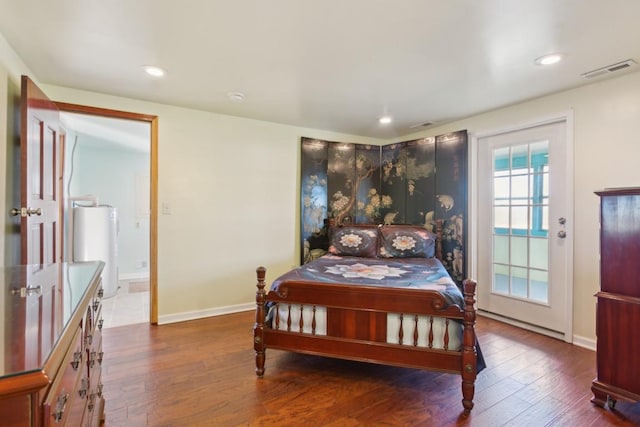 bedroom with dark hardwood / wood-style flooring and water heater