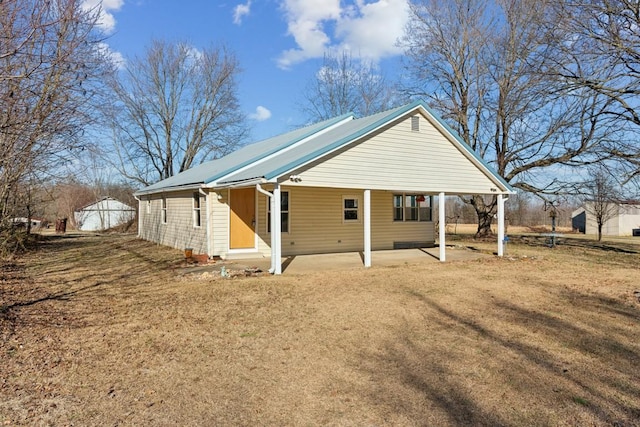 rear view of property featuring a lawn