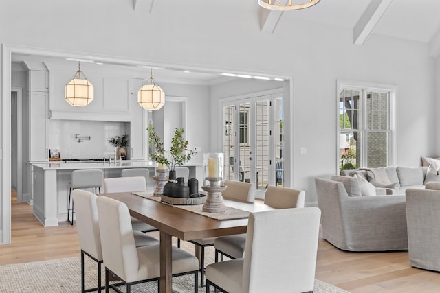 dining space featuring beamed ceiling and light hardwood / wood-style floors