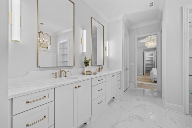 bathroom featuring ornamental molding, vanity, and a notable chandelier