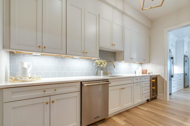 kitchen featuring sink, light hardwood / wood-style flooring, decorative backsplash, stainless steel dishwasher, and beverage cooler