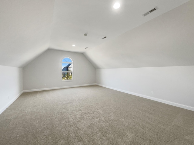 bonus room with vaulted ceiling and carpet floors