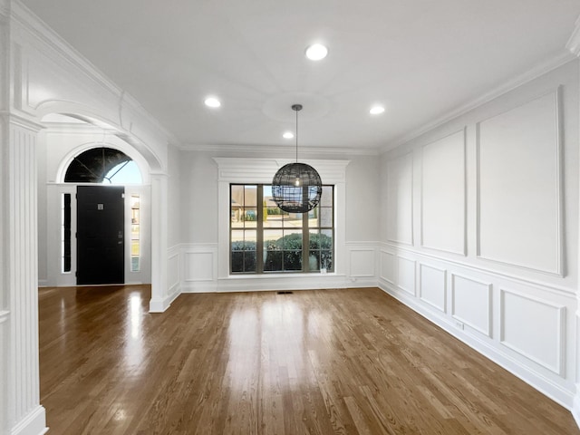 unfurnished dining area with dark hardwood / wood-style flooring and crown molding