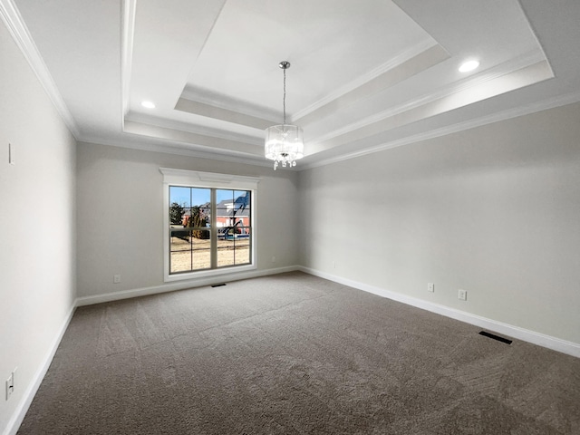 carpeted empty room with ornamental molding, a raised ceiling, and a notable chandelier