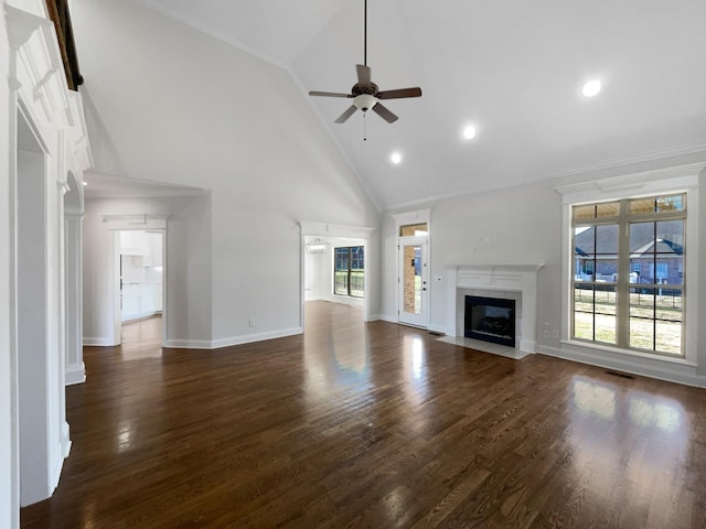 unfurnished living room with crown molding, ceiling fan, high vaulted ceiling, a fireplace, and dark hardwood / wood-style flooring