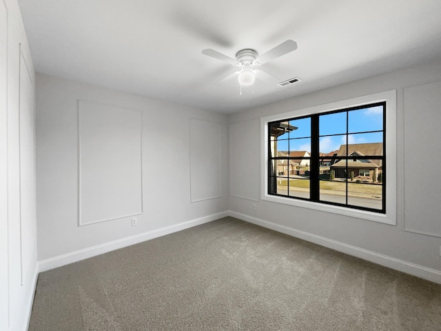 carpeted spare room with ceiling fan