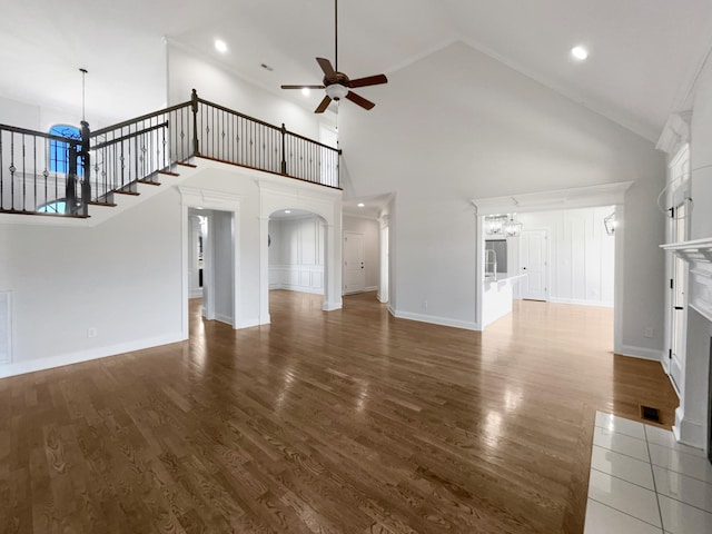 unfurnished living room featuring high vaulted ceiling, dark hardwood / wood-style floors, and ceiling fan