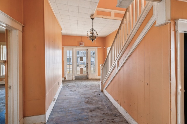 foyer entrance featuring wood-type flooring and a chandelier