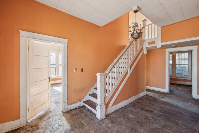 stairs with wood-type flooring and a chandelier