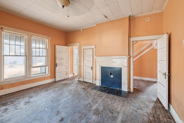 unfurnished living room featuring crown molding