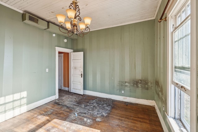 unfurnished room with an inviting chandelier and wood-type flooring