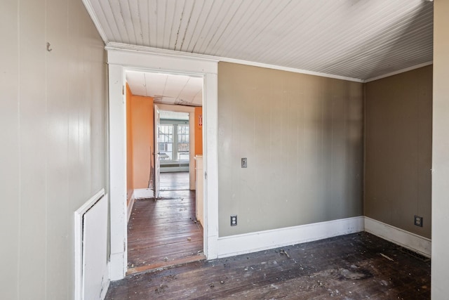 empty room featuring crown molding and dark wood-type flooring