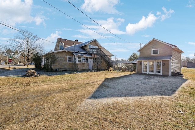 back of property with french doors and a yard