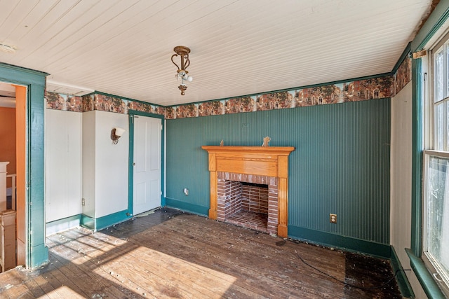 unfurnished living room with a brick fireplace and dark hardwood / wood-style floors