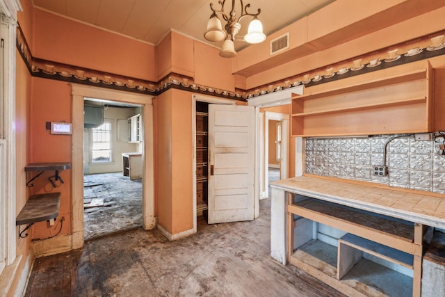 kitchen with a notable chandelier, decorative light fixtures, and tile countertops