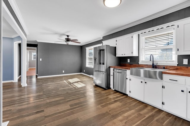 kitchen with sink, dark wood-type flooring, white cabinetry, stainless steel appliances, and wood counters