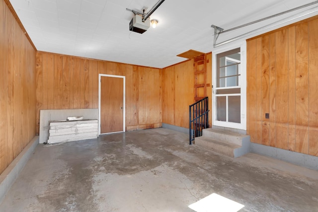 garage featuring a garage door opener and wooden walls