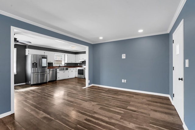 unfurnished living room with crown molding, ceiling fan, sink, and dark wood-type flooring