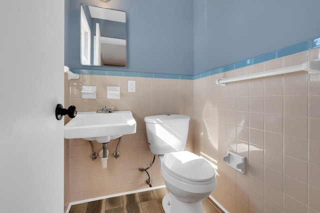 bathroom with hardwood / wood-style floors, tile walls, and toilet