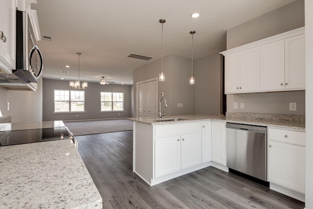 kitchen featuring sink, decorative light fixtures, stainless steel appliances, and white cabinets